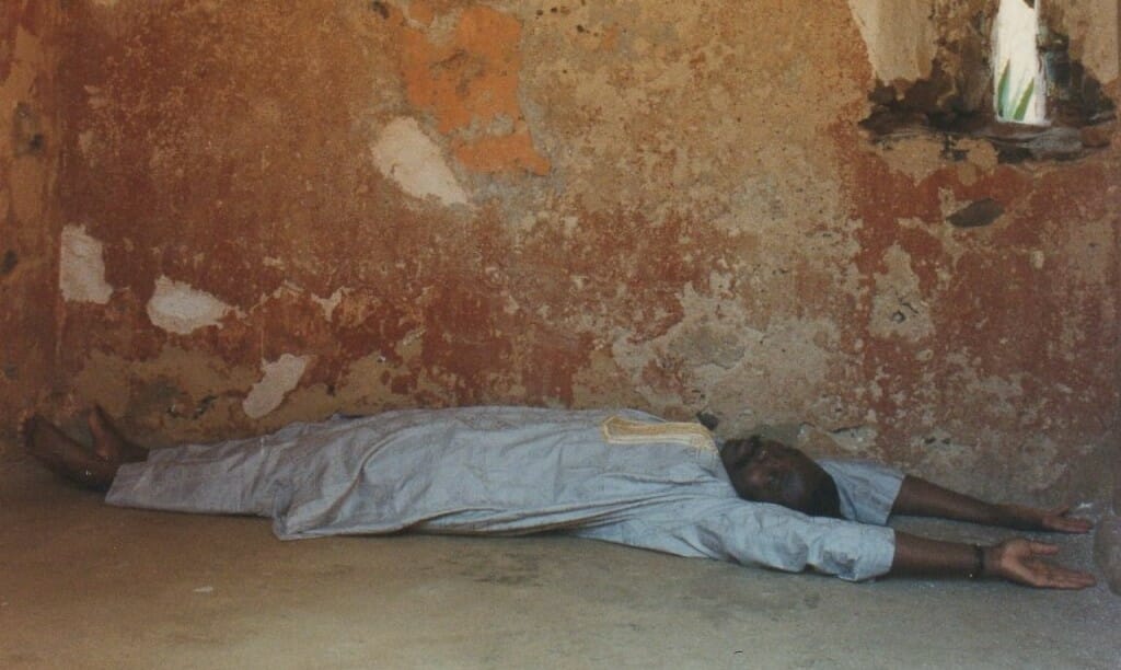 "The African" reporter Soumanou Salifou lies down in one of the cells to give the reader a measure of the size of the dungeons where slaves where kept.