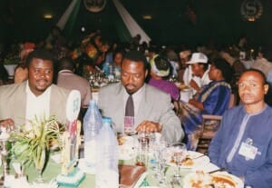 Salifou dines with "The African" photographer Arsene Kassegne, left, during President Obasanjo's 1999 inaugural 