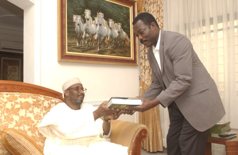Former Governor Alhaji Ahmadu Adamu Mu’azu gives an autographed copy of his Tenure Repor to The African Magazine's poublisher Soumanou Salifou at his residence in Abuja in 2010. Image by Arsene Kassegne.
