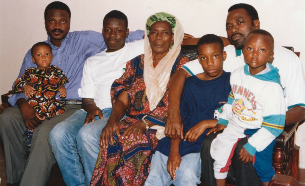 Hadeejah Salifou surrounded by a few of her children and grand-children in this picture shot in 1997: From left to right: Youngest son, Ganiou (with his second son Ted sitting on his lap), grand-son Samir, Hadeejah, grand-son Jonathan, oldest son Soumanou (with Ganiou's oldest son Nelson sitting on his lap). Image by Franck Johnson.
