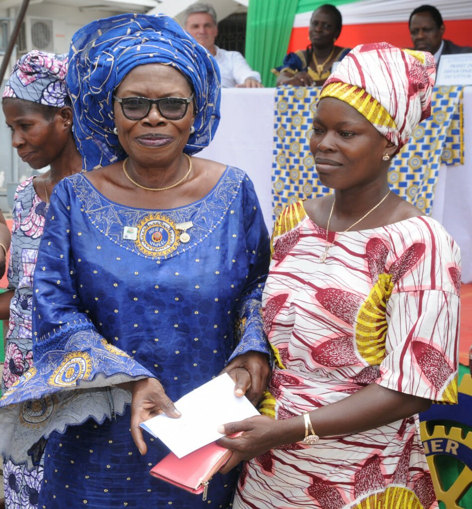 A healed obstetric fistula patient, right, is handed an en envelope of cash by Past District Governor Fahimatou Salifou.
