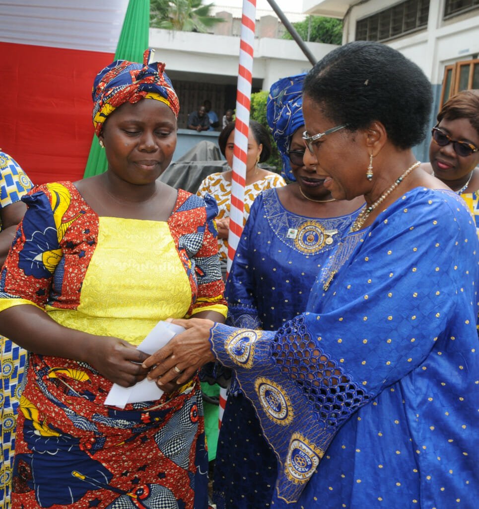 A healed obstetric fistula patient, left, is handed an en envelope of cash by Past District Governor Marie-Paule Gudibi.