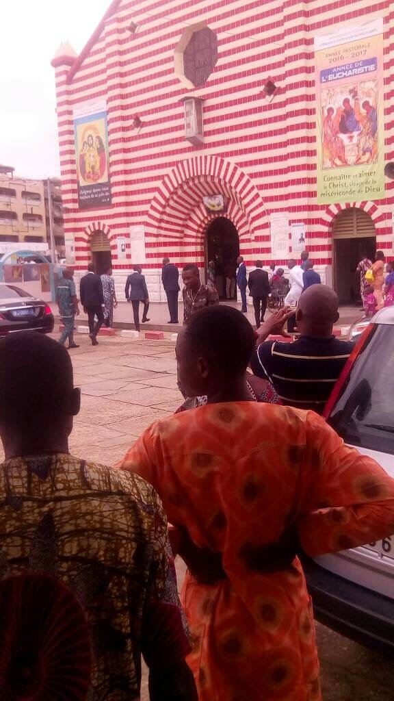 A simultaneously-gathered crowd watches President Talon enter church on July 9