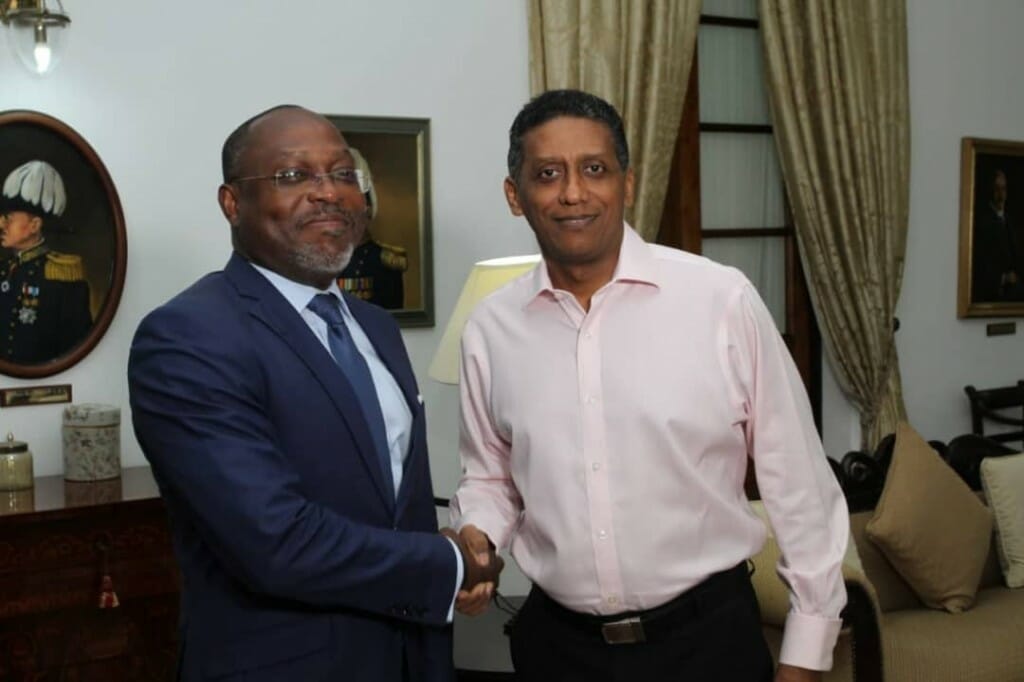The Seychelles president, Danny Faure, right, shakes hands with high-profile African economist, Dr. Samuel Mathey.