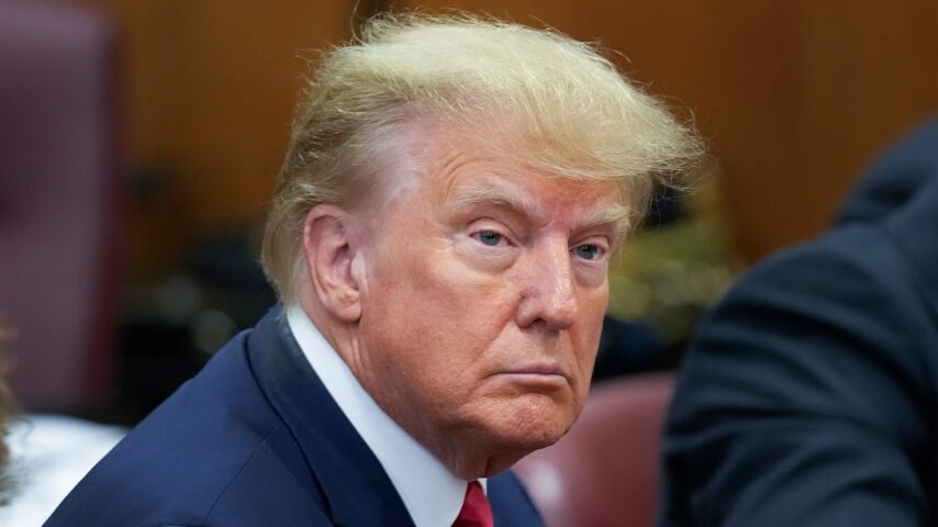 Former president Donald Trump listens as the charges of his indictment are being read to him