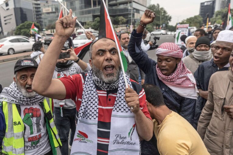 Protesters shout slogans and wave flags during a pro-Palestinian demonstration near the US consulate in Sandton, Johannesburg,