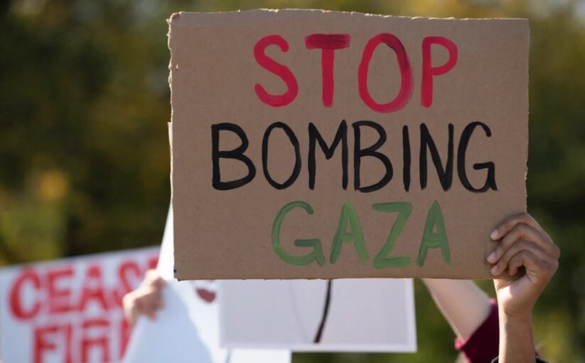 A demonstrator holds a carboard calling for the end of Israel's bombing campaign on Gaza