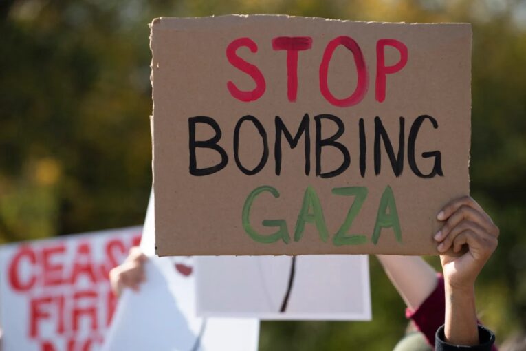 A demonstrator holds a carboard calling for the end of Israel's bombing campaign on Gaza