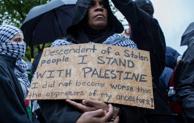 A demonstrator holds a carboard calling for the end of Israel's bombing campaign on Gaza