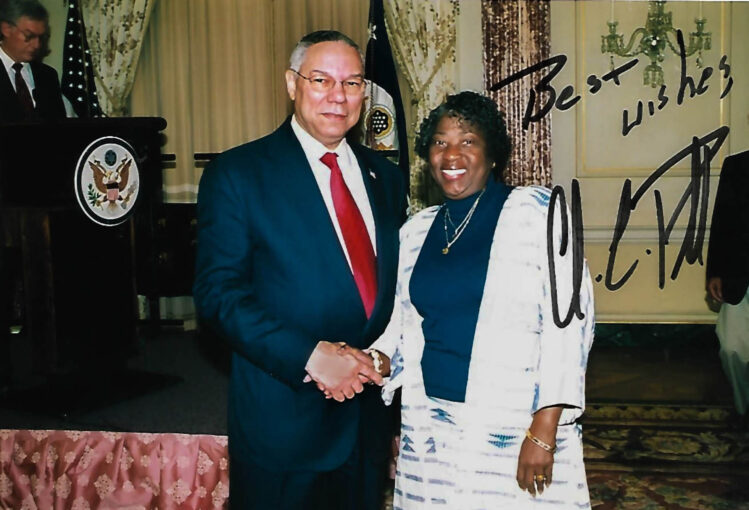 Then-Secretary of State Colin Powell wishes Marva Long well with a handshake in his office in 2002 as she is about to retire from the civil service