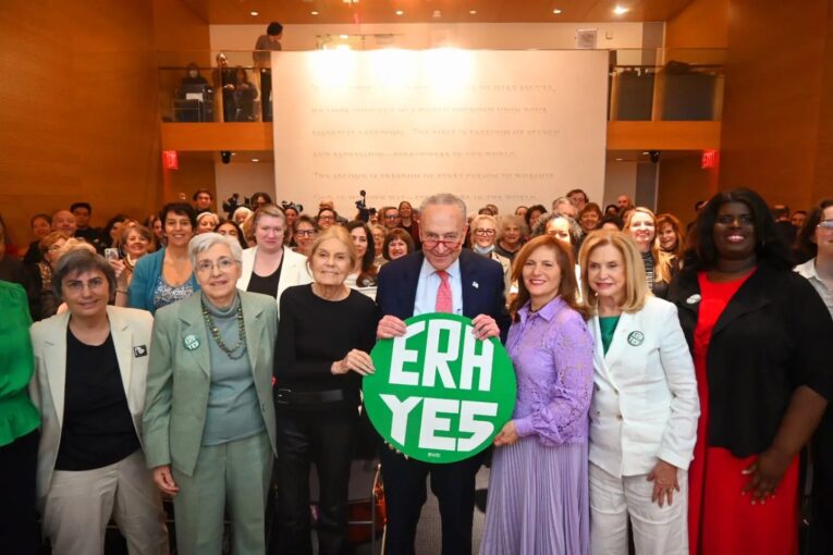 NOW’s leadership takes their fight for Equal Rights Amendment to the U.S. Senate. Then-Senate Majority Leader Chuck Schumer (D-NY) holds the ERA sign, surrounded by the women. Photo credit: NOW.
